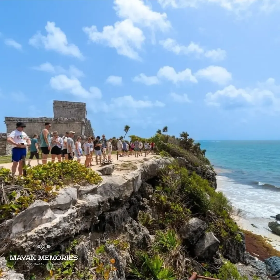 Visitors on the path beside El Castillo in Tulum above the sea