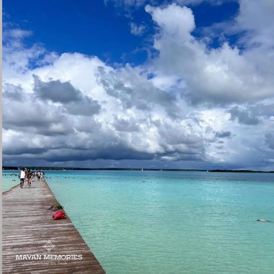 Wooden pier stretching into the Bacalar lagoon under clouds