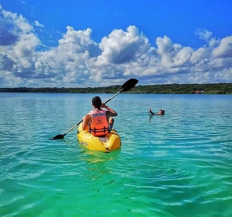 Person paddling a yellow kayak on the Bacalar lagoon