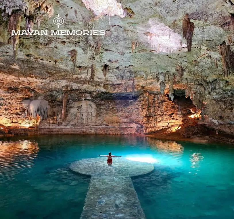 Cave cenote with turquoise water and a swimmer under the vault