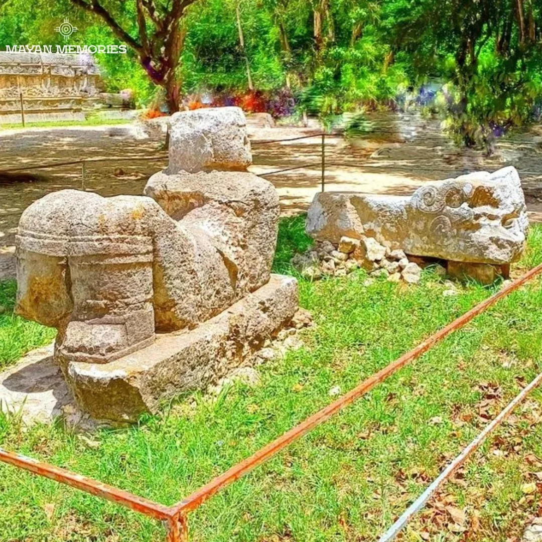 Cabezas de serpiente talladas en piedra sobre el pasto
