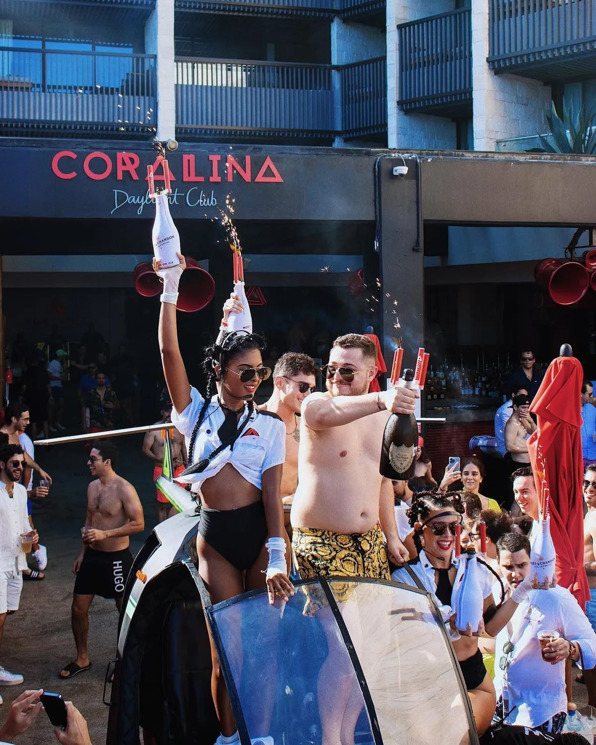 Personas celebrando con botellas y bengalas en la fiesta