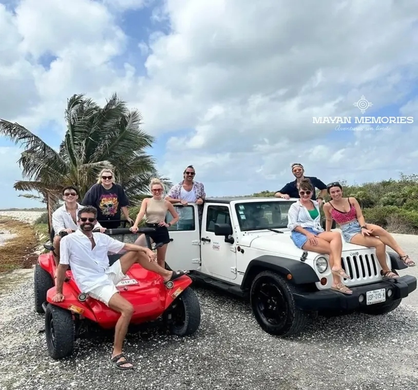 Group with a white jeep and a red buggy by the sea
