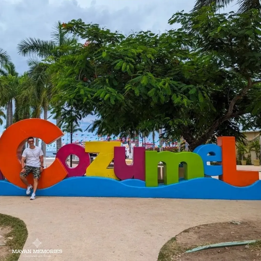 Mujer posando frente a las letras de colores de Cozumel