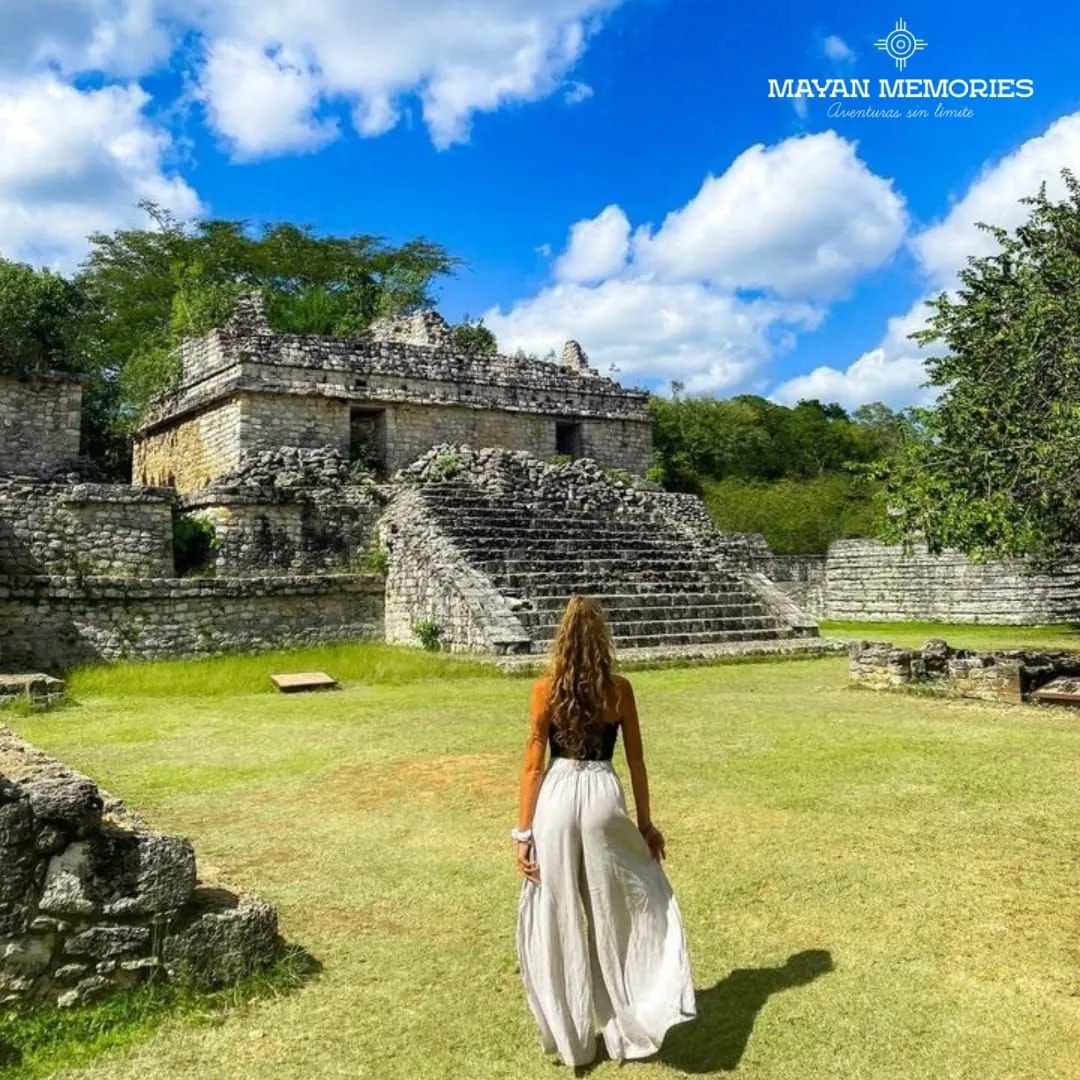 Woman walking toward a Mayan temple across the lawn