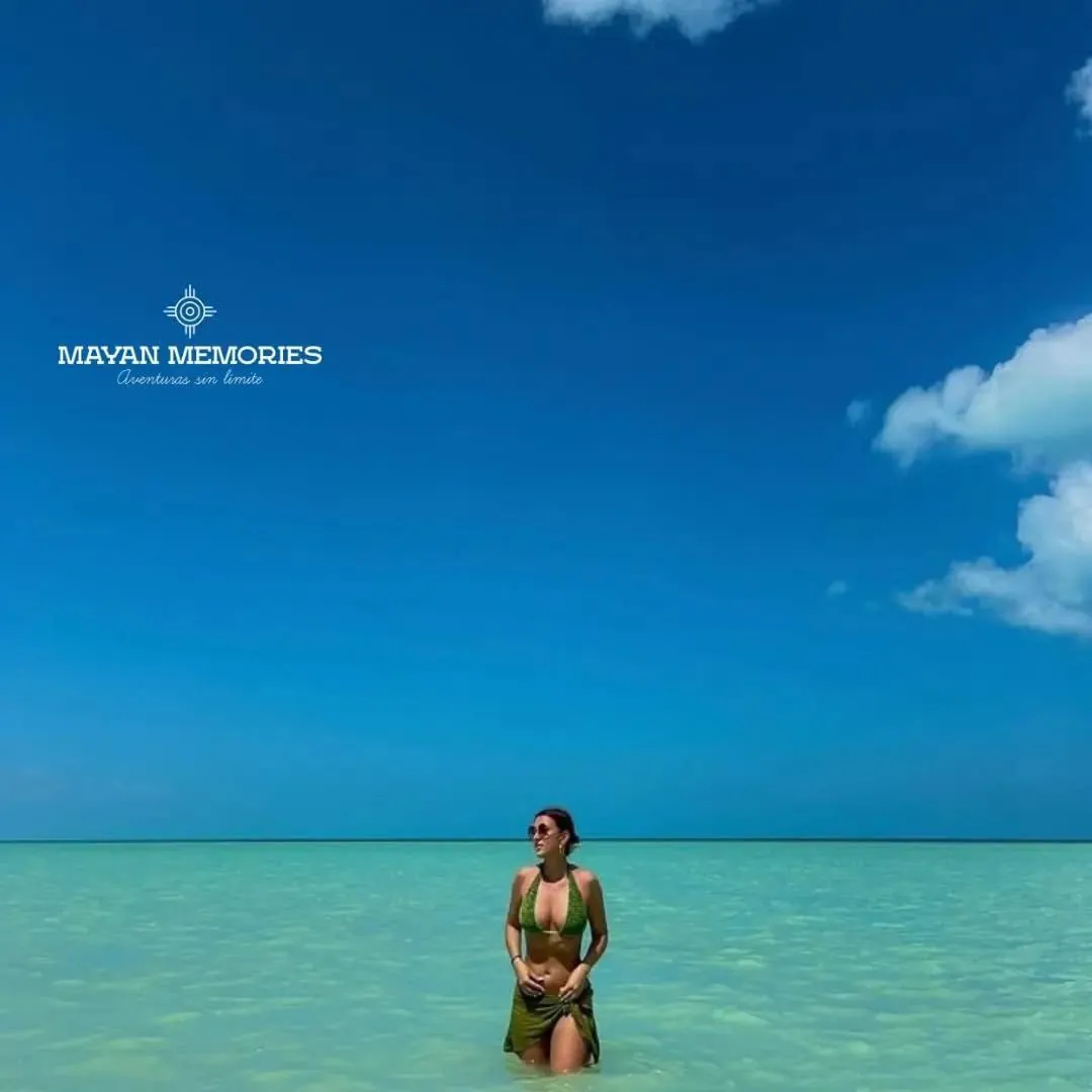 Person standing in the shallow turquoise water of Holbox