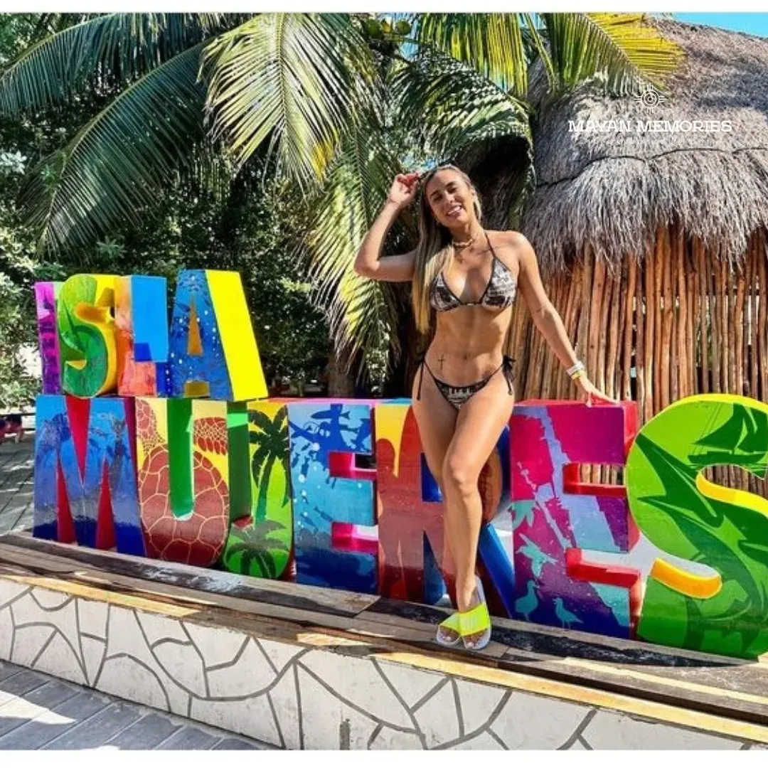 Mujer en bikini posando en las letras de colores de Isla Mujeres