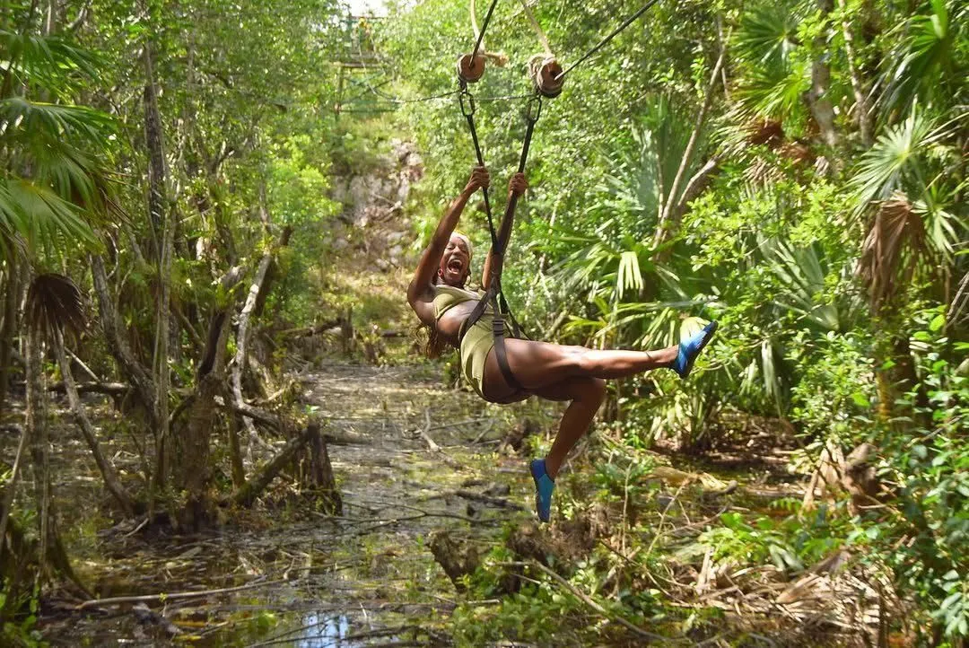 Person hanging from a rope above the jungle