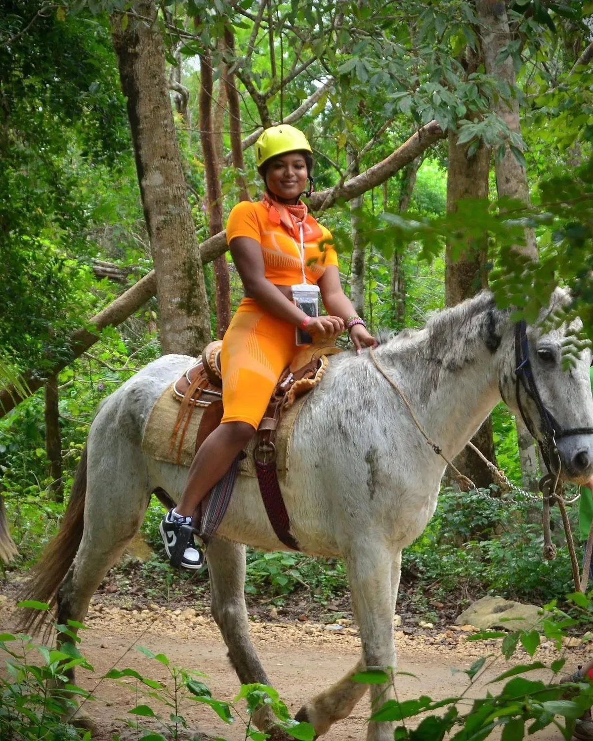 Woman riding a white horse in the jungle