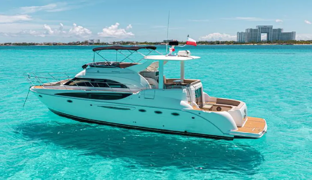 White Meridian yacht in turquoise water with hotels behind