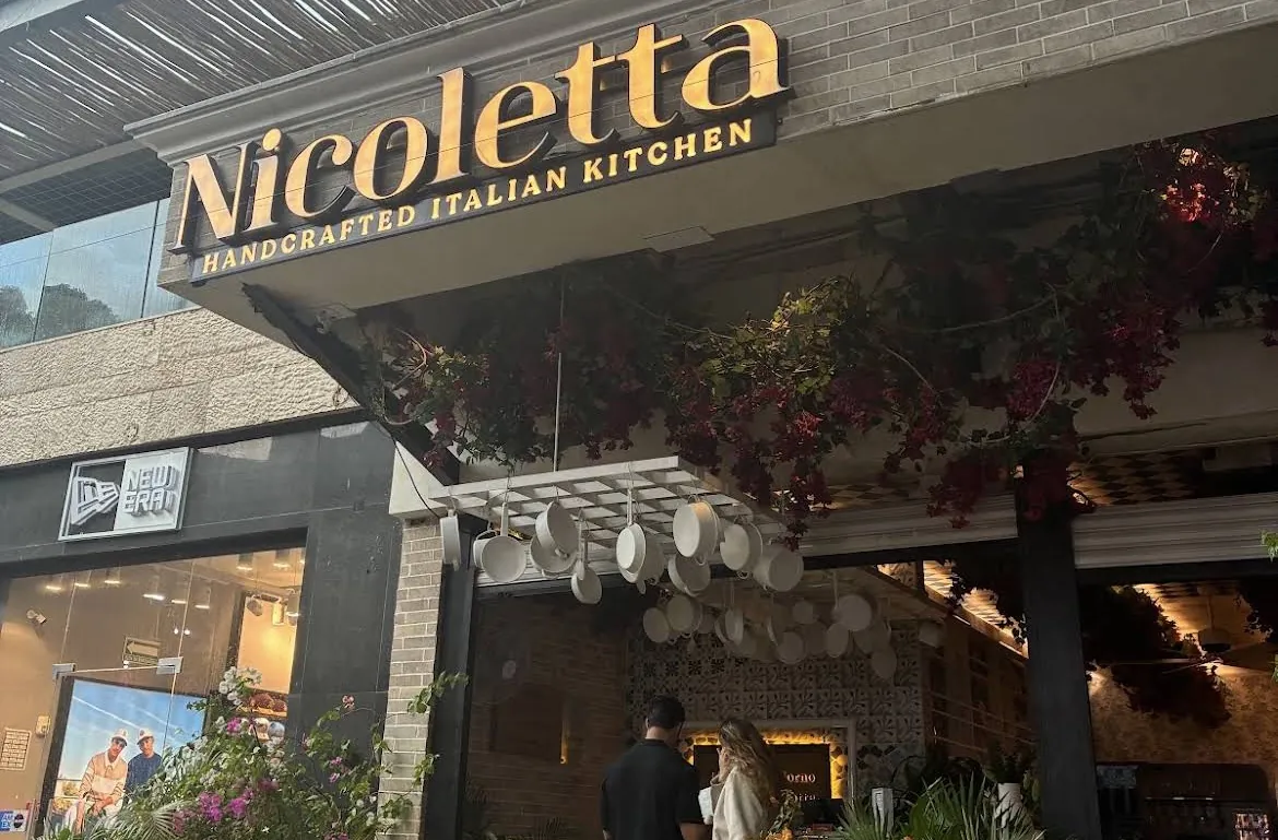 Fachada de Nicoletta con su letrero y mesas en la terraza