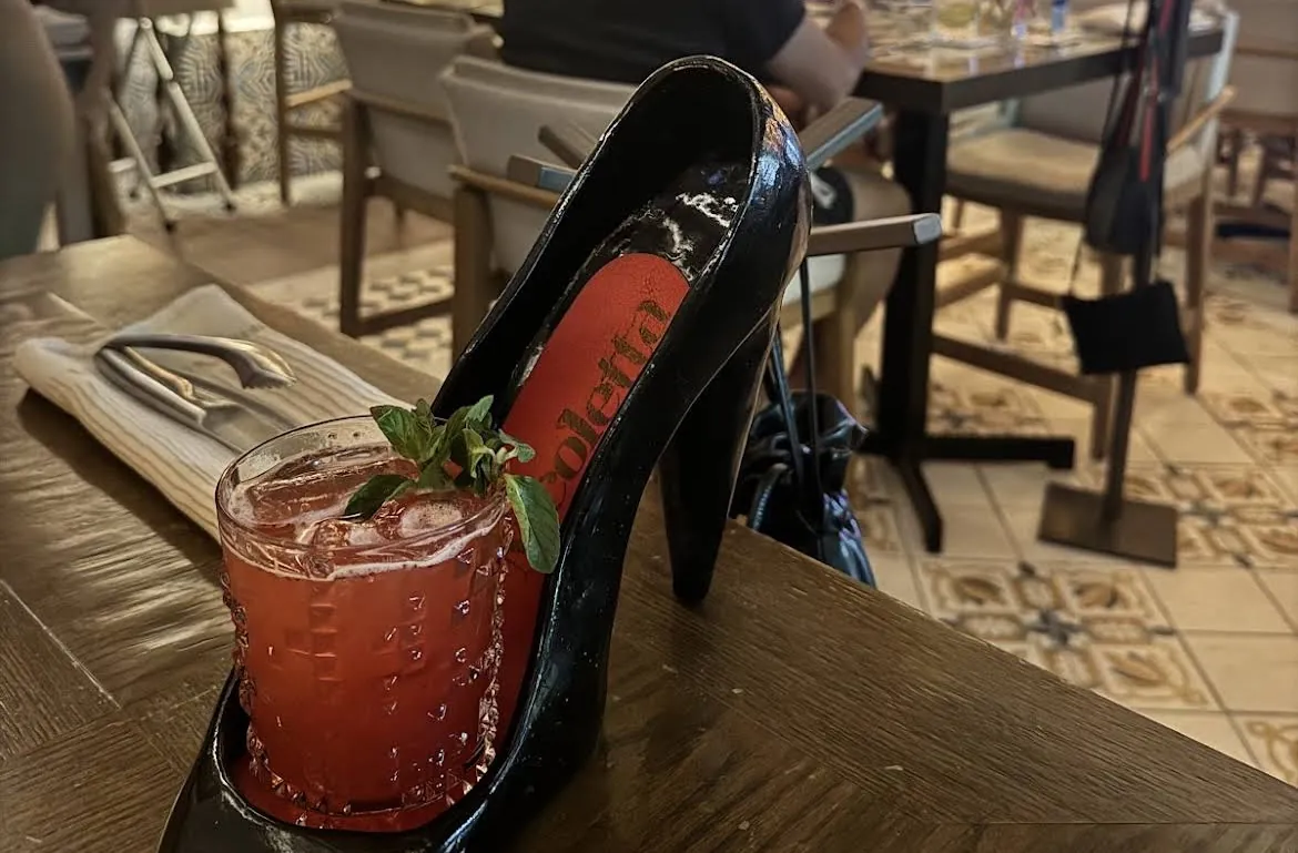 Red cocktail served in a high-heel-shaped glass