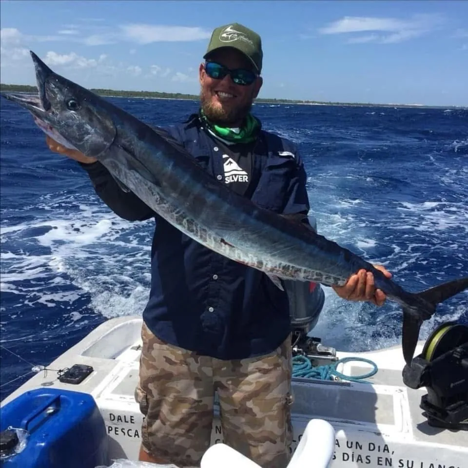 Angler holding a large fish on board a boat