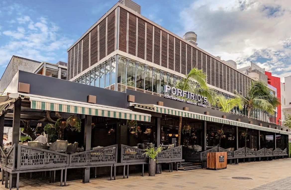 Fachada de Porfirio's con terrazas y vegetación