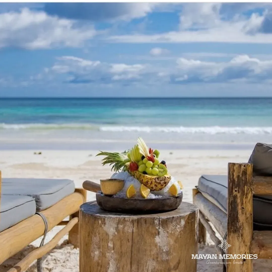 Plato de fruta sobre la mesa con la playa y el mar al fondo