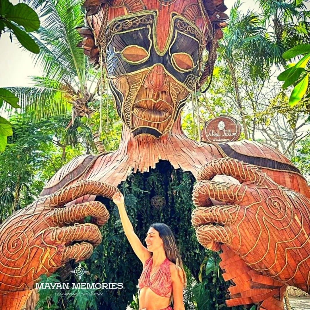 Visitante entre las manos de la gran escultura de madera de la Madre Naturaleza
