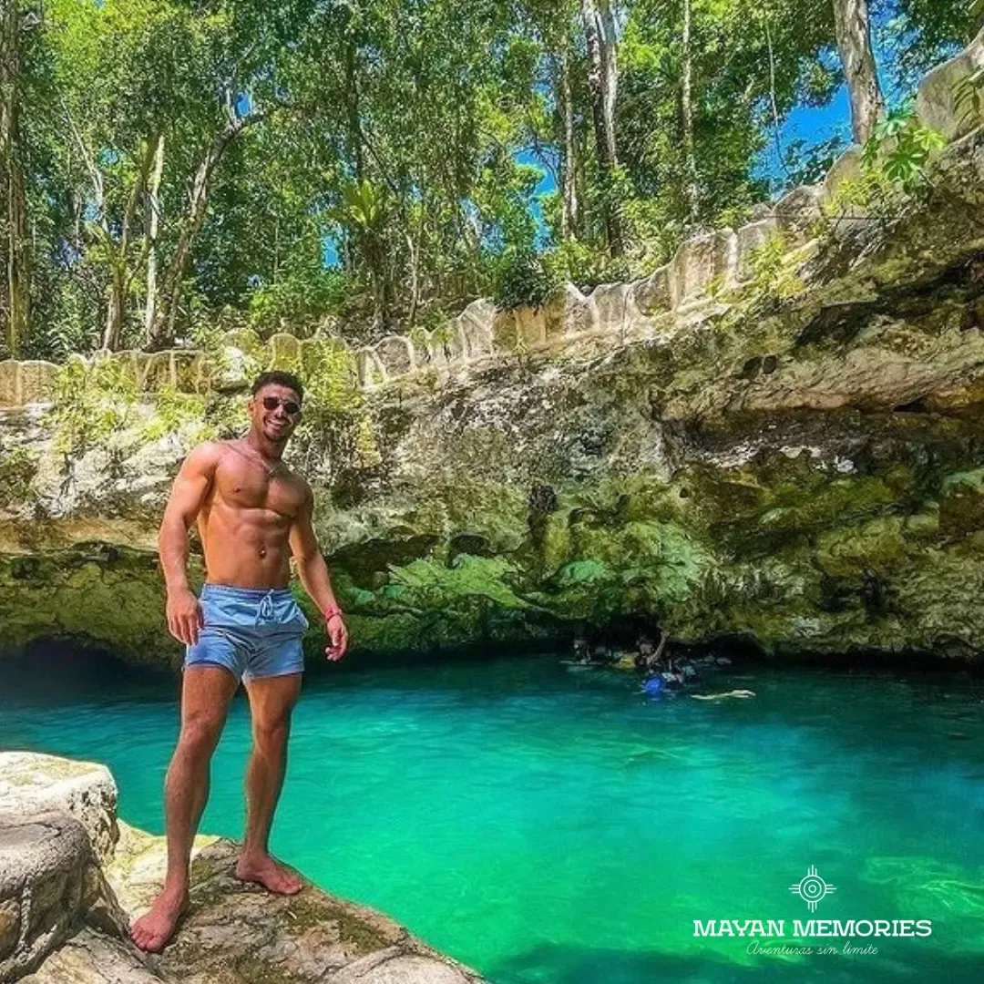 Man standing beside an open turquoise cenote