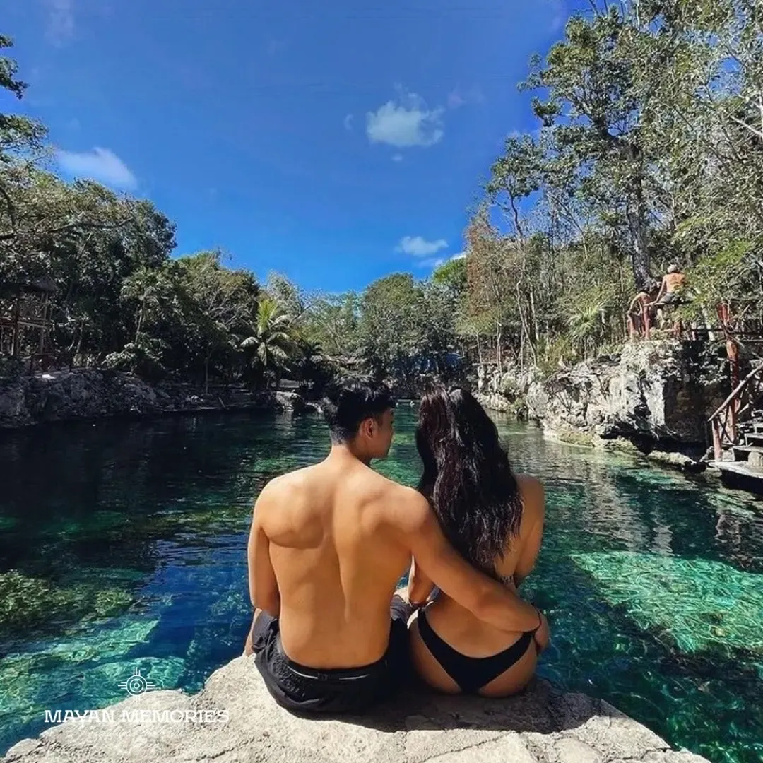 Couple seen from behind looking out over an open cenote