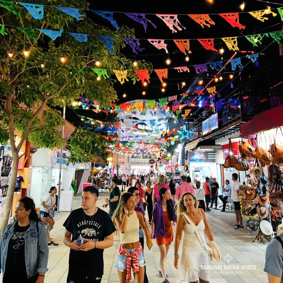 Quinta Avenida de Playa del Carmen con papel picado y paseantes