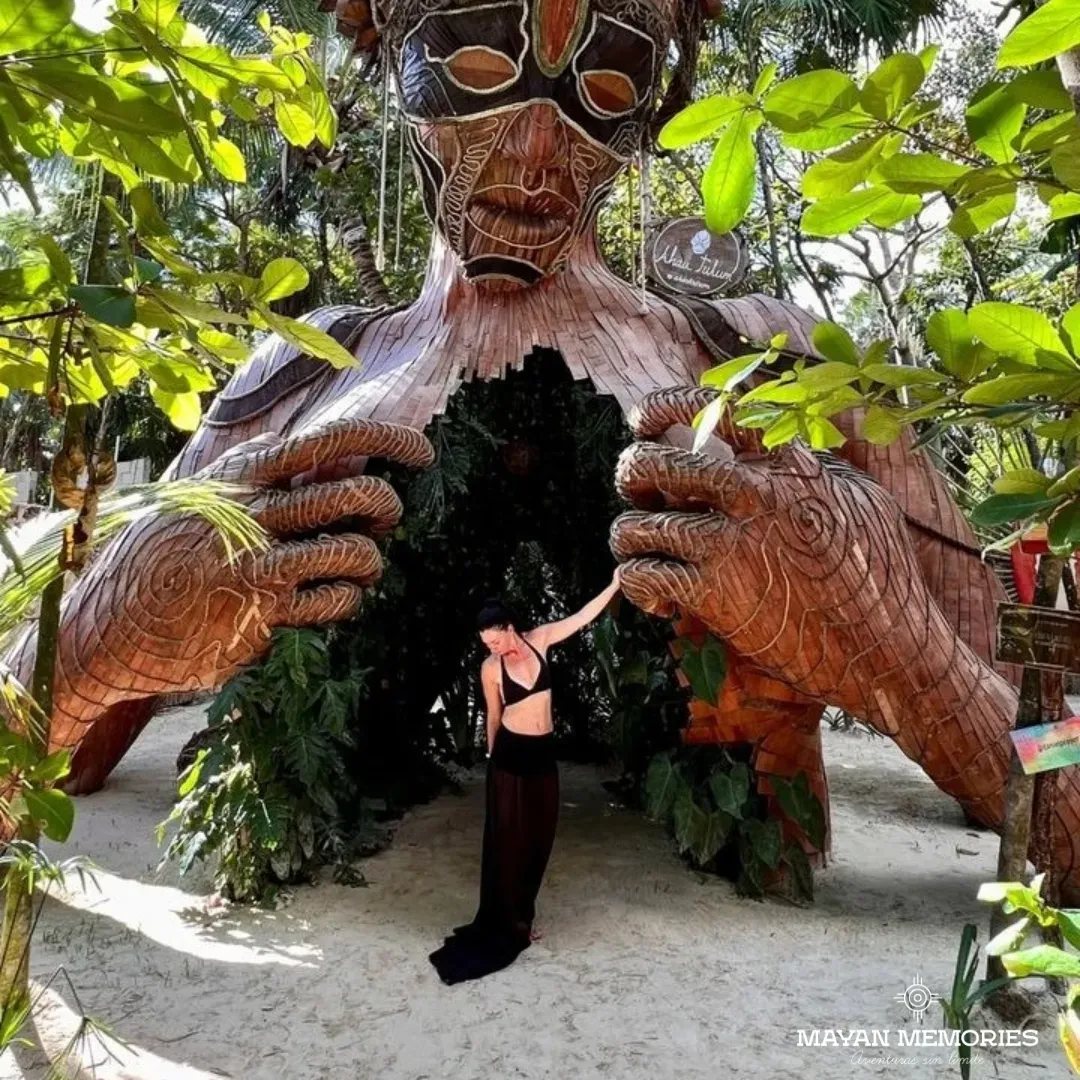 Visitante entre las manos de la escultura de madera de la Madre Naturaleza