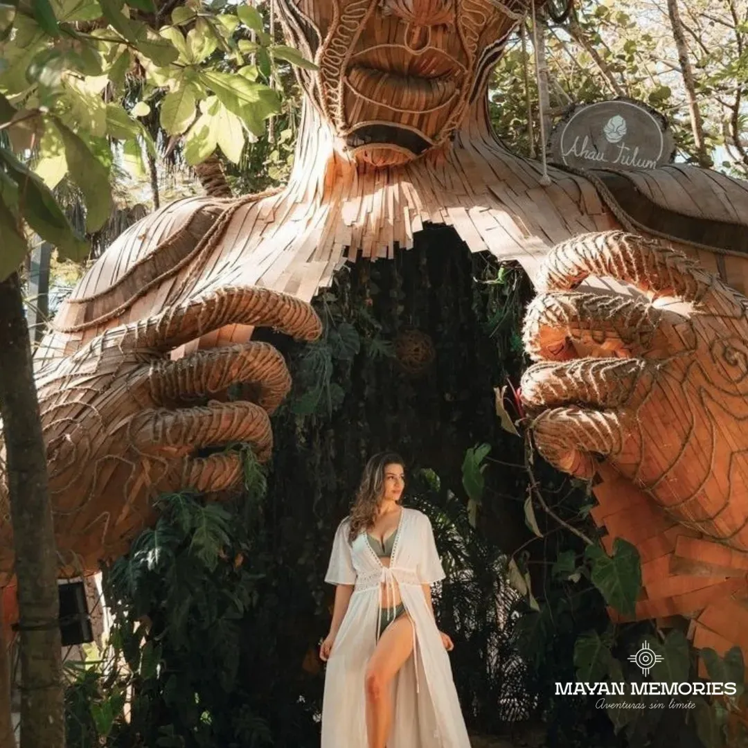 Mujer de blanco entre las grandes manos de la escultura de madera